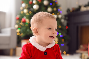 Cute little baby in Santa costume at home on Christmas eve