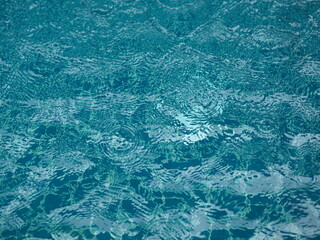 blue water in pool background ripples on the surface texture, glittering bokeh abstract