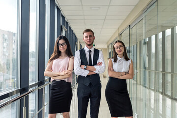 Three beautiful business partners discussing paperwork in modern .office hallway