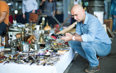 Portrait of mature man looking for vintage goods at flea market