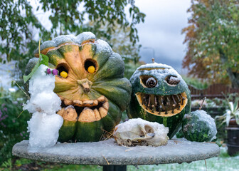 first snow, carved decorative pumpkins in the garden, first snow on pumpkin decors, halloween, pumpkin decor