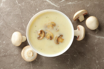 Bowl of tasty mushroom soup on gray background
