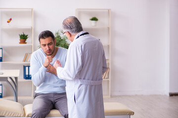 Obraz premium Young sick man visiting old doctor