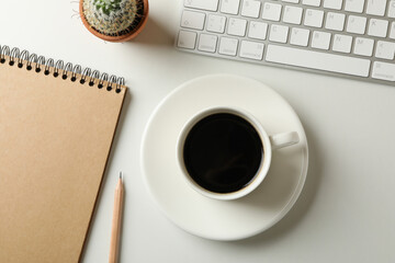 Workplace with cup of coffee on white background