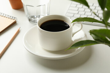 Workplace with cup of coffee on white background