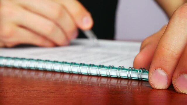 One man fills out a form with a pen