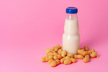 Non-dairy vegan milk made of nuts in glassware against pink background