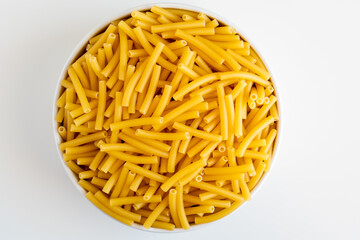 Raw dry uncooked Macaroni pasta spaghetti noodle on white bowl wooden background for basil tomato pesto sauce Homemade Italian food organic whole wheat vegan spaghetti for a healthy meal