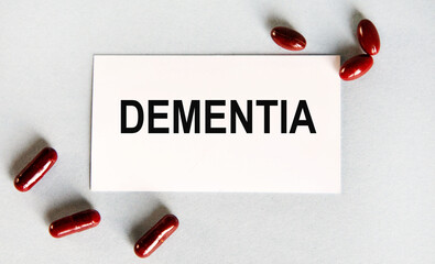 On the card is the text of DEMENTIA, next to the red capsules.
