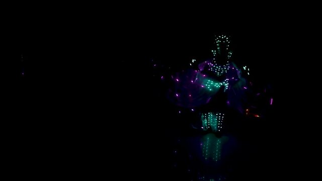 Laser show, dancers in costumes with LED lamps. very beautiful night club party.