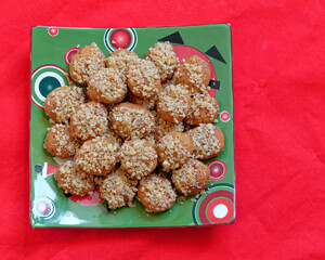melomacarona, traditional Greek Christmas gourmet cookies with honey syrup and nuts, served on red fabric background