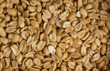 fried, salty peanuts. A calorie bomb. Unhealthy snack. Background.