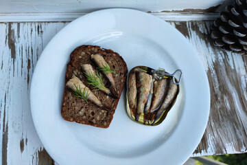 smoked sprats. black bread sandwich with sprats