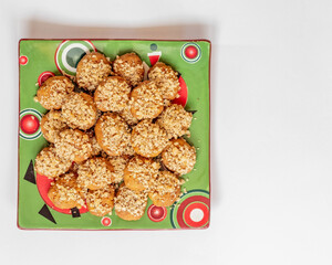 melomacarona plate, traditional Greek Christmas gourmet cookies with honey syrup and nuts on white background