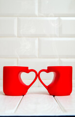two heart shaped mugs with tea on white background
