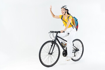 Fototapeta na wymiar Asian beautiful woman, she is riding a city bike to work.She is greeting.