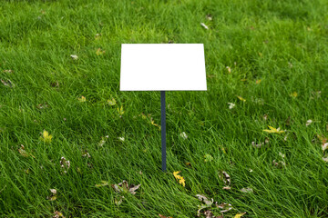 Empty sign board on grass with space for caption. Property house for sale sign board. Notice board...