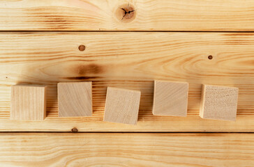 Groupped wooden square blocks on dark wooden table
