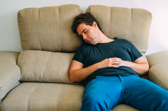 Young Fat Readhead Nerd Sleeping on a Cream Couch Sofa Wearing Black T-Shirt