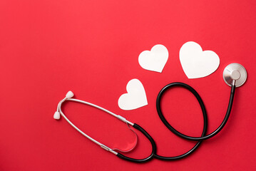 hearts and stethoscope , heart health care concept, red background with copy space