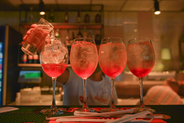 Barman makes alcoholic cocktails in nightclub. Bartender at work making alcohol drinks in a bar or restaurant.