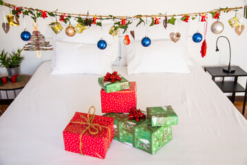 Authentic Chrismas presents on top of bed with cozy decoration.