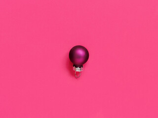 Purple Christmas bauble on a pink background
