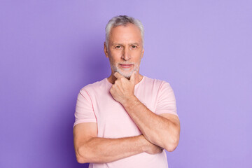 Photo of pensioner old man hand chin ponder look camera wear pink t-shirt isolated violet color...