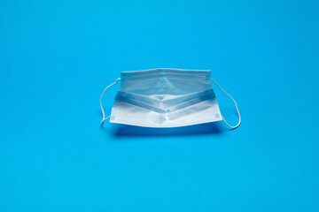 Disposable blue medical face mask on blue background