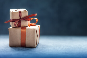 Holidays present or gift boxes with brown ribbon on dark background