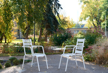 White garden autumn park relax chairs. Fall season, weekend, still life, leisure time concept. Selective focus, copy space.