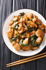 Sanbeiji is a popular chicken dish in Chinese cuisine closeup on the plate on the table. Vertical top view from above