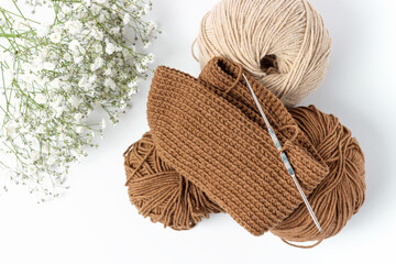 A yarn and a knitting hook on white background, view from above