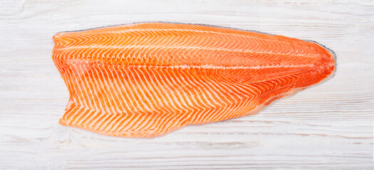 Half raw salmon fillet on wooden table