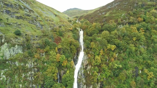 Idyllic Snowdonia mountain range Aber falls waterfalls national park aerial view slow rising