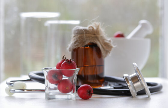 Red berries hawthorn and tincture and stethoscop.