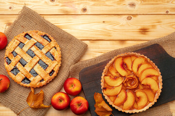 Thanksgiving berry and apple various pies on wooden surface, top view