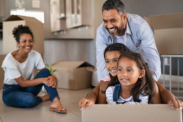Mixed race family with kids enjoying moving in new house