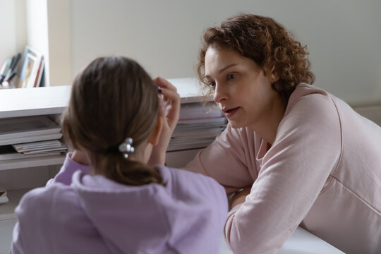 Caring Caucasian mother talk support unhappy upset teen daughter suffering from school bullying or discrimination problems. Loving mom comfort cheer sad teenage girl child, make peace after fight.