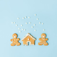 Happy New Year's set of house, gingerbread man in face mask from ginger biscuits glazed sugar icing decoration on blue background, minimal seasonal pandemic winter holiday banner, stay home