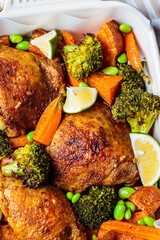 Baked chicken with vegetables, gray background, close up.