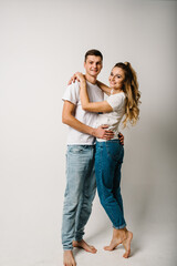 Couple in denim casual style clothes. Fashion models on white background. Smiling young man and woman posing together. Happy family couple.