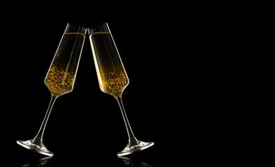 two glasses of champagne clink glasses on a black background