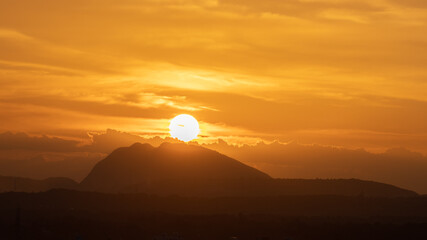Silhouette of a hill against beautiful golden hour light and beautiful clouds formation in the...