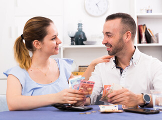 Couple is distributing the family budget at home.