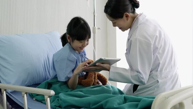 Asian doctor nurse pediatrician woman visiting child girl patient and empathy to the diagnosis when visit doctor. Concept of medical, healthcare, healthy family, pediatric checkup and hospital office.