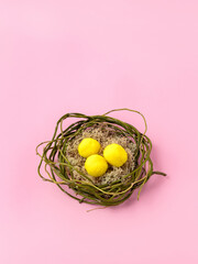 Creative layout made with nest, pompom, eggs, leaves and branches on pink background. Minimal Easter or food concept. Top view, flat lay, close up, copy space.