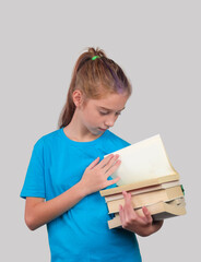 A little girl holds stack of school books