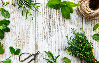 Fresh herbs and twine on wooden background top view
