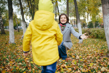 The family walks in the autumn park on a cloudy day.